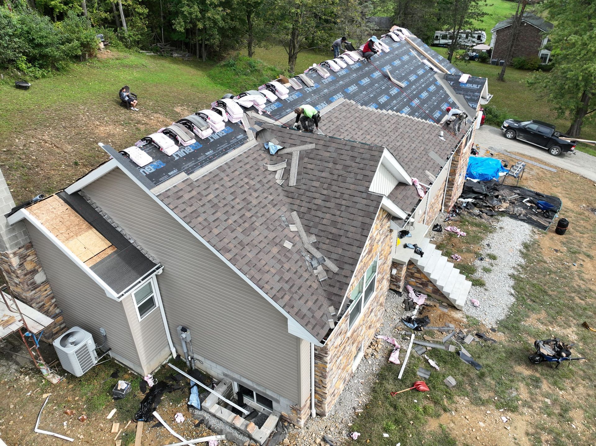 An aerial view of a house under construction with a roof being installed.