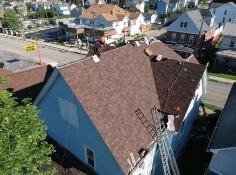 An aerial view of a house with a ladder on the roof.