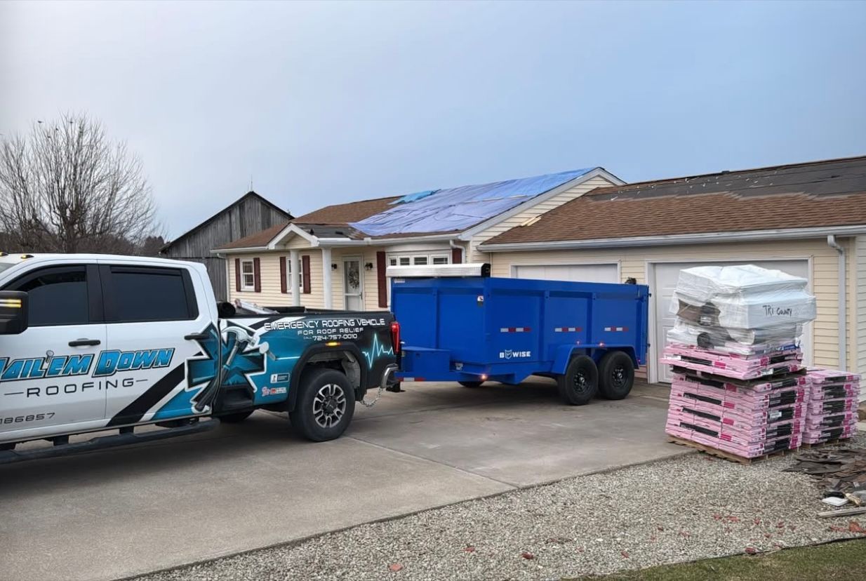 A truck and trailer are parked in front of a house.