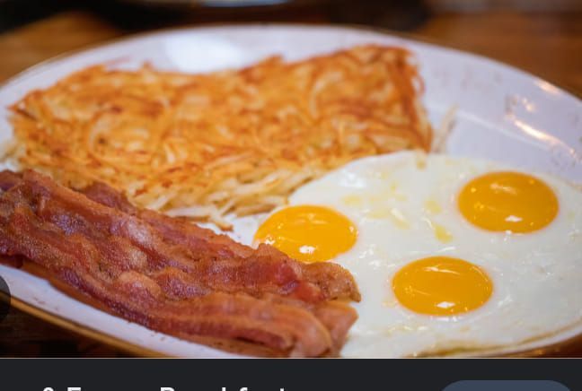 A white plate topped with eggs bacon and hash browns