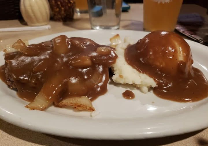 A plate of food with mashed potatoes and gravy on a table