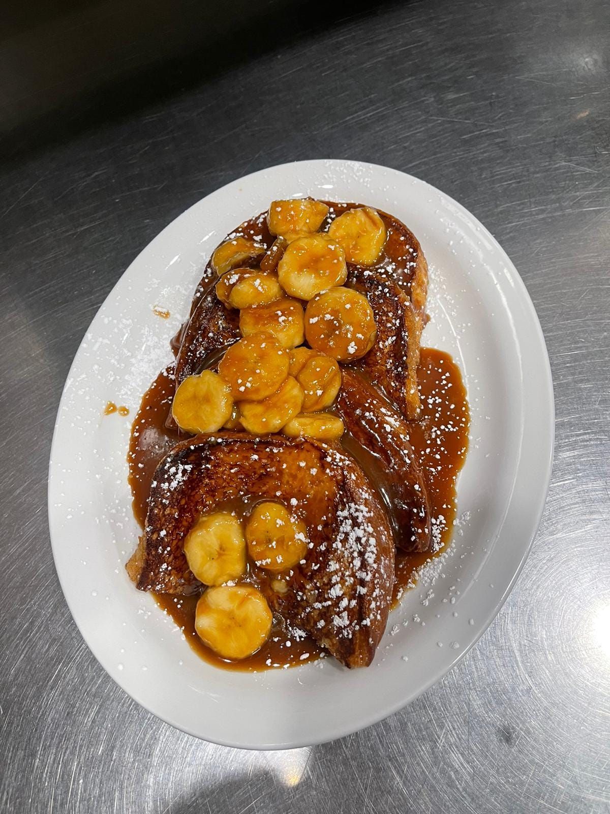A white plate topped with french toast and bananas