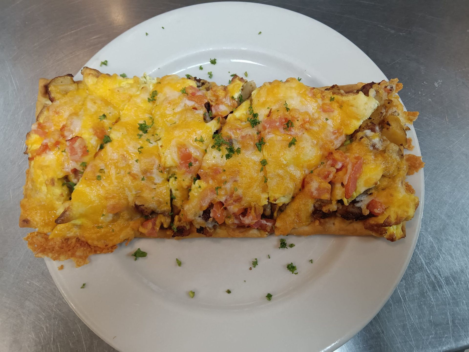 A white plate topped with a slice of pizza on a table.