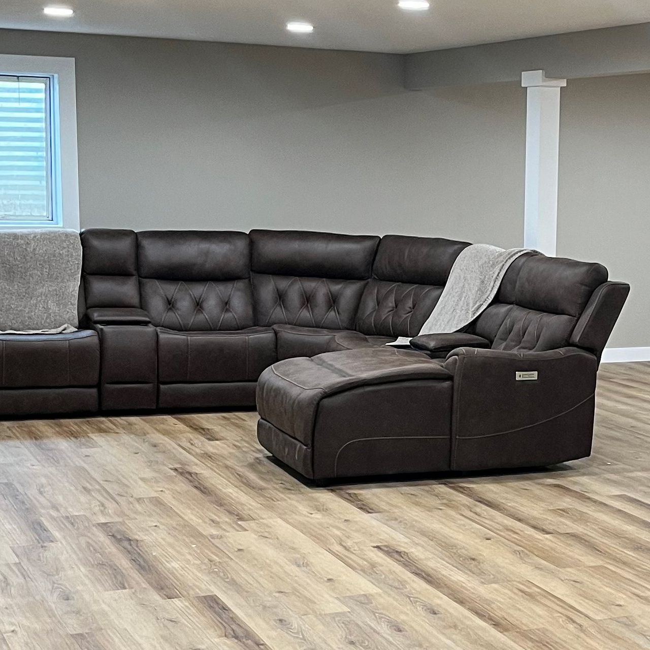 A living room with a large sectional couch and ottoman.