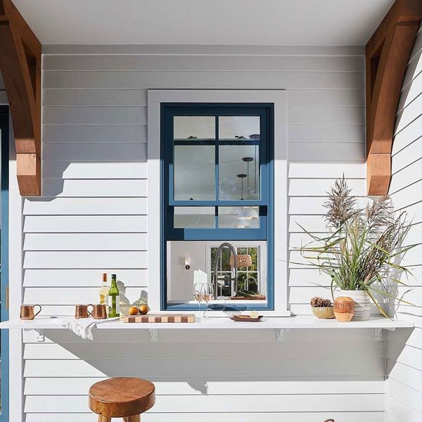 A white house with a blue window and a counter