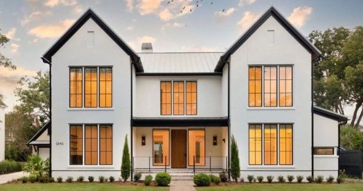 A large white house with black trim and a lot of windows