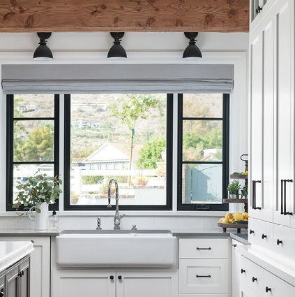 A kitchen with a sink, cabinets, and a window.