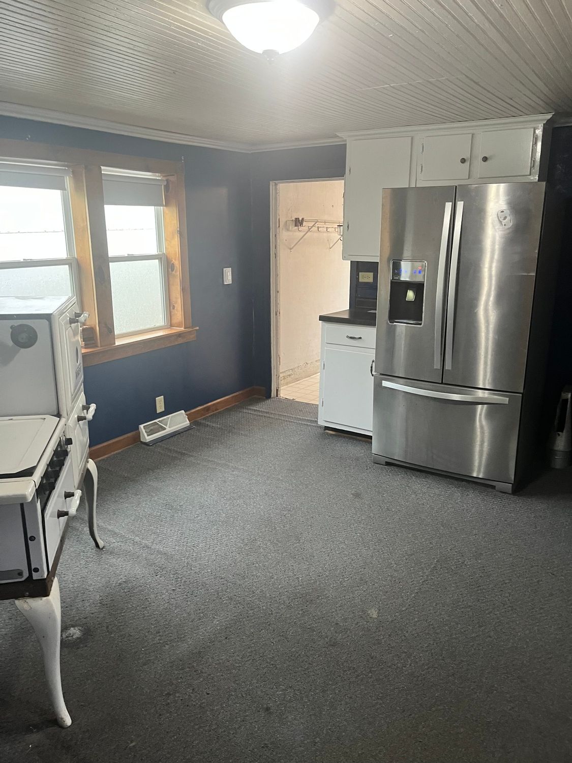 A kitchen with a stainless steel refrigerator and a stove.