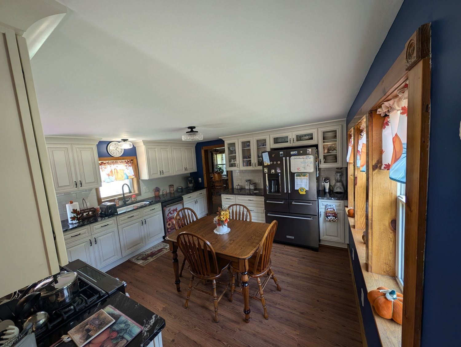 A kitchen with a table and chairs and a refrigerator.