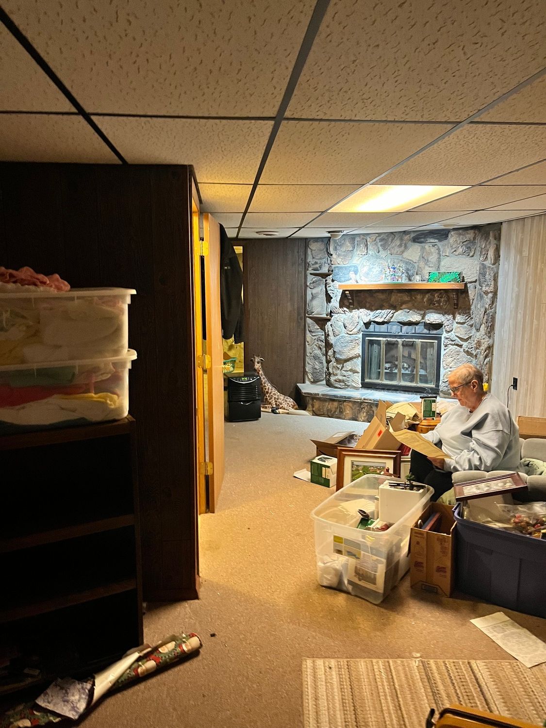 A man is sitting in a living room with a fireplace.
