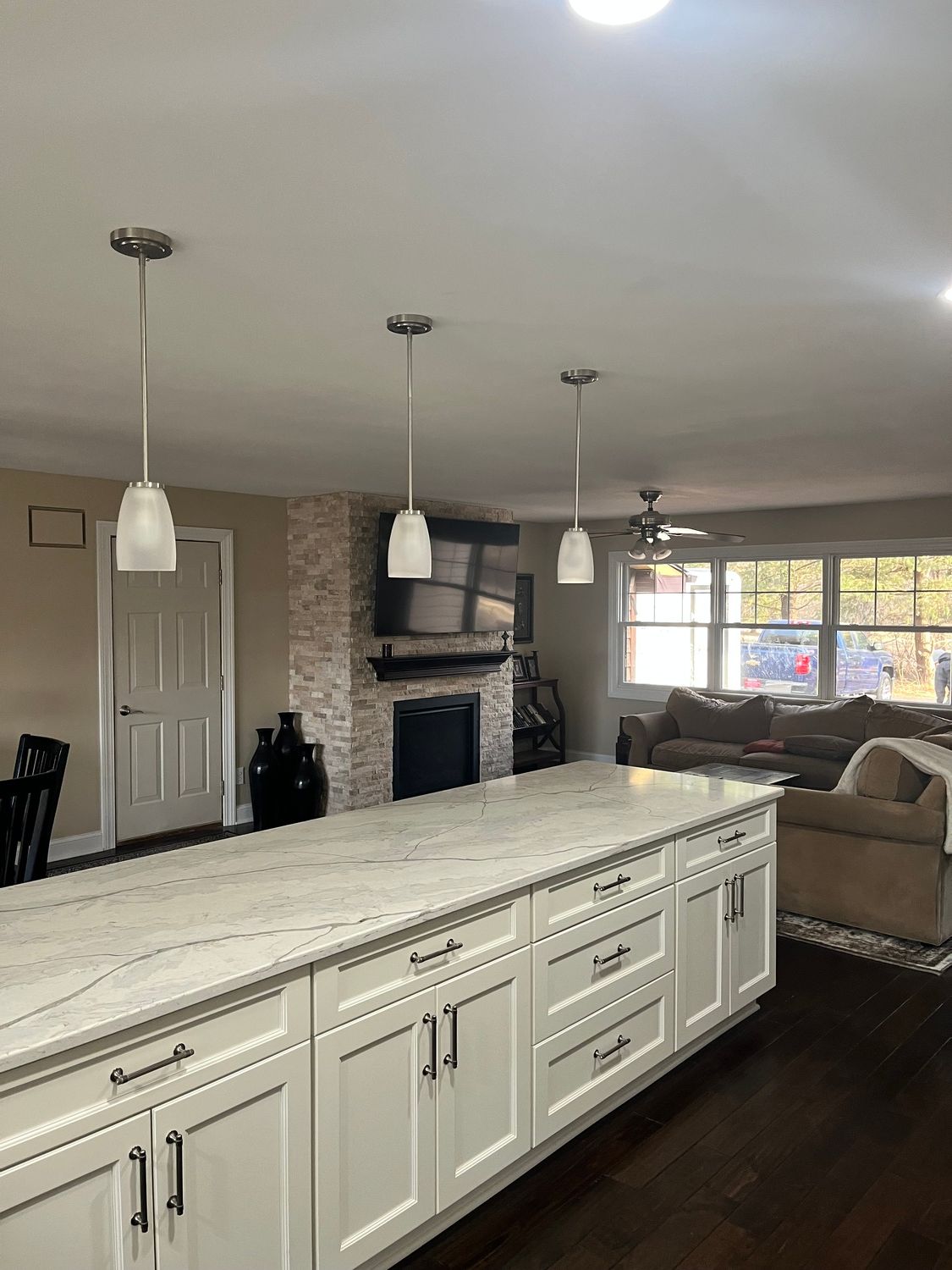A kitchen with white cabinets and a large island in the middle of the room.
