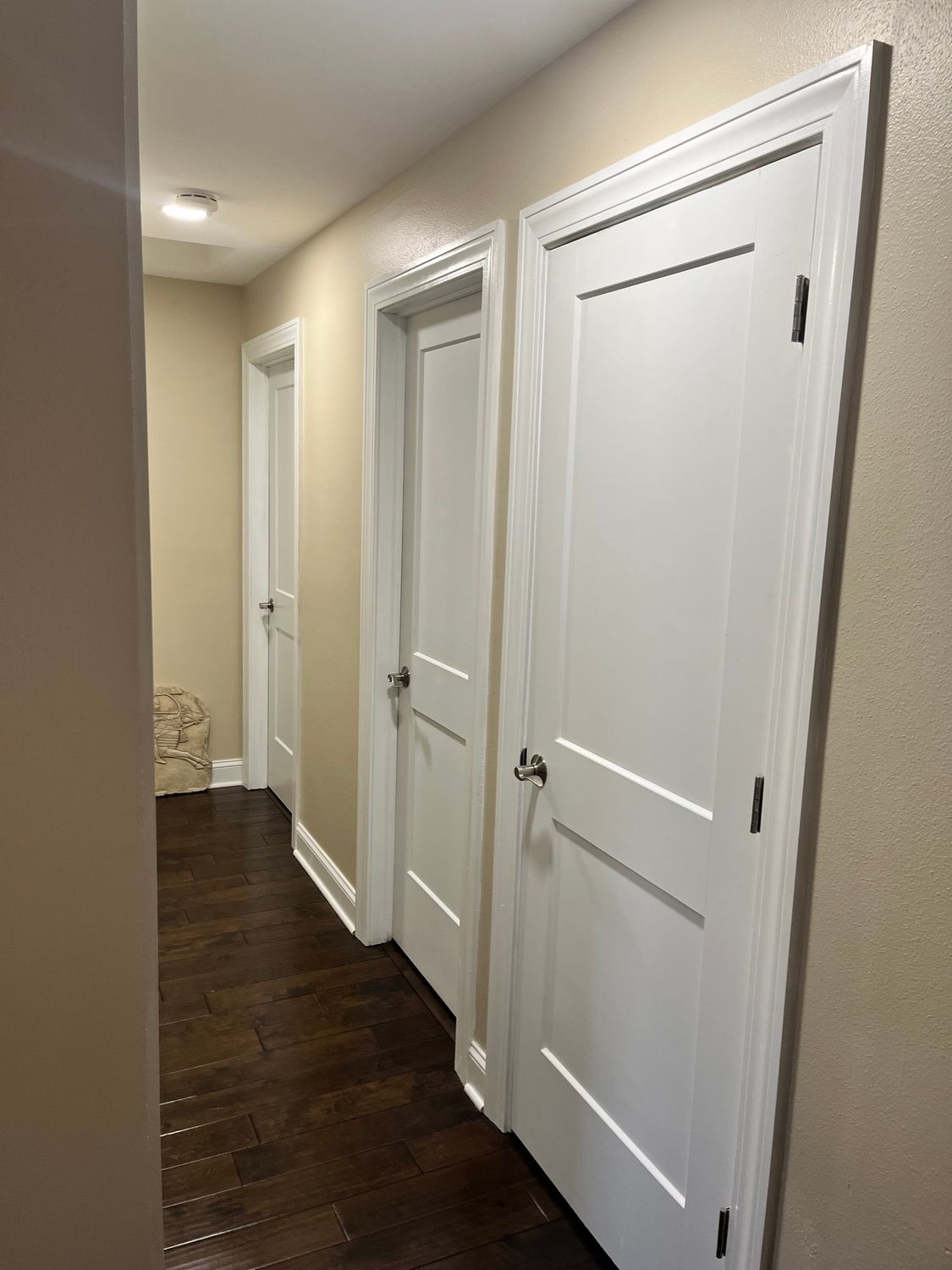 A hallway with white doors and a wooden floor