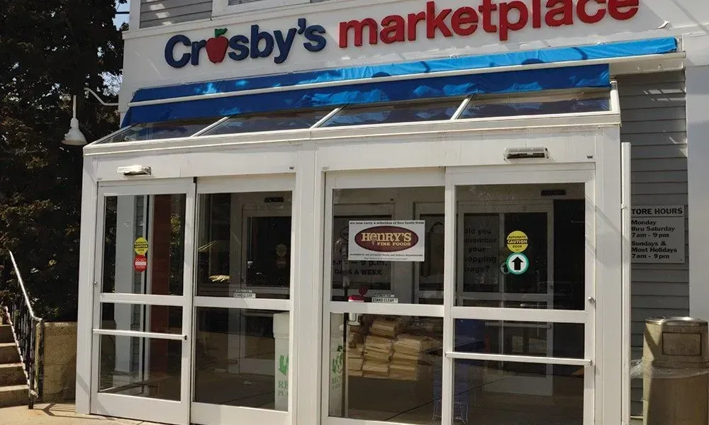 Crosby’s Marketplace storefront with glass entrance and blue-white sign above the door