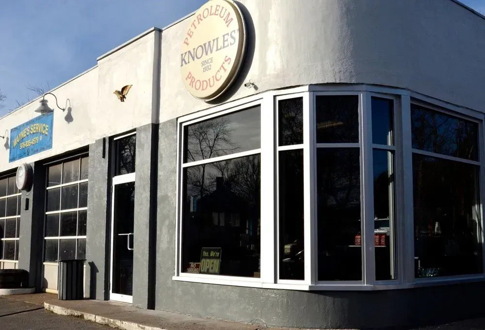 Storefront with large windows and a round “Snowie’s” sign on a sunny street corner