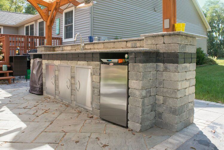 There is a stainless steel refrigerator in the middle of the kitchen.