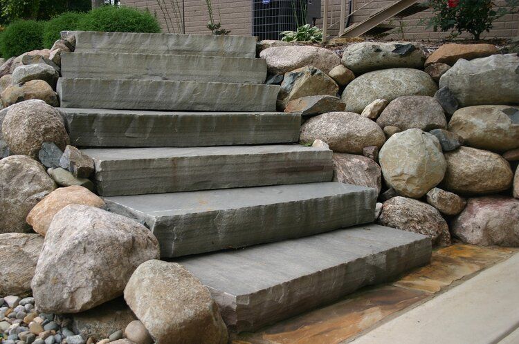 A set of stairs surrounded by rocks in a garden.