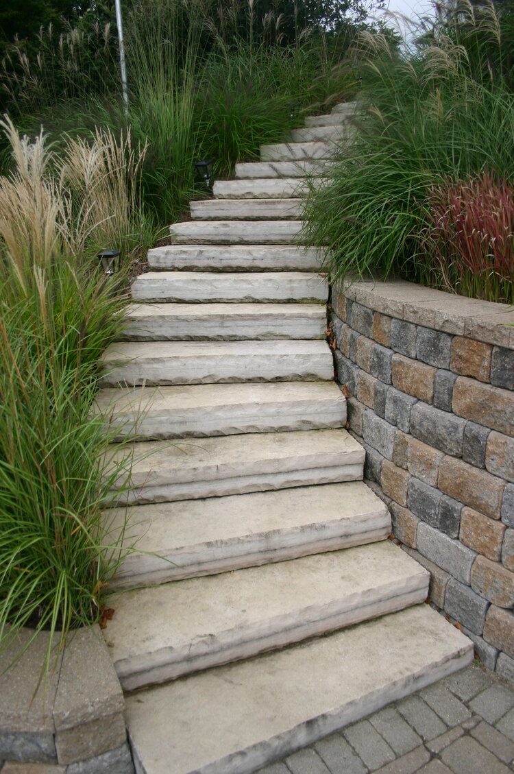 A set of stone stairs leading up to a brick wall.