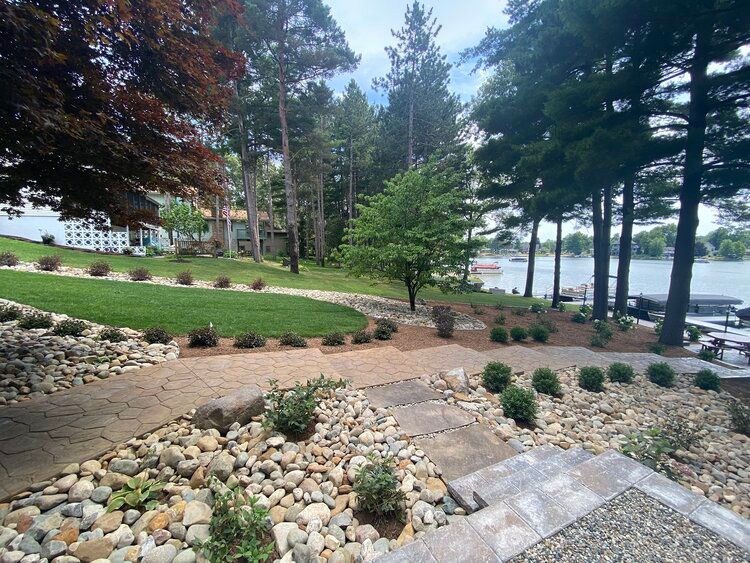 A rocky path leading to a lake with trees in the background.