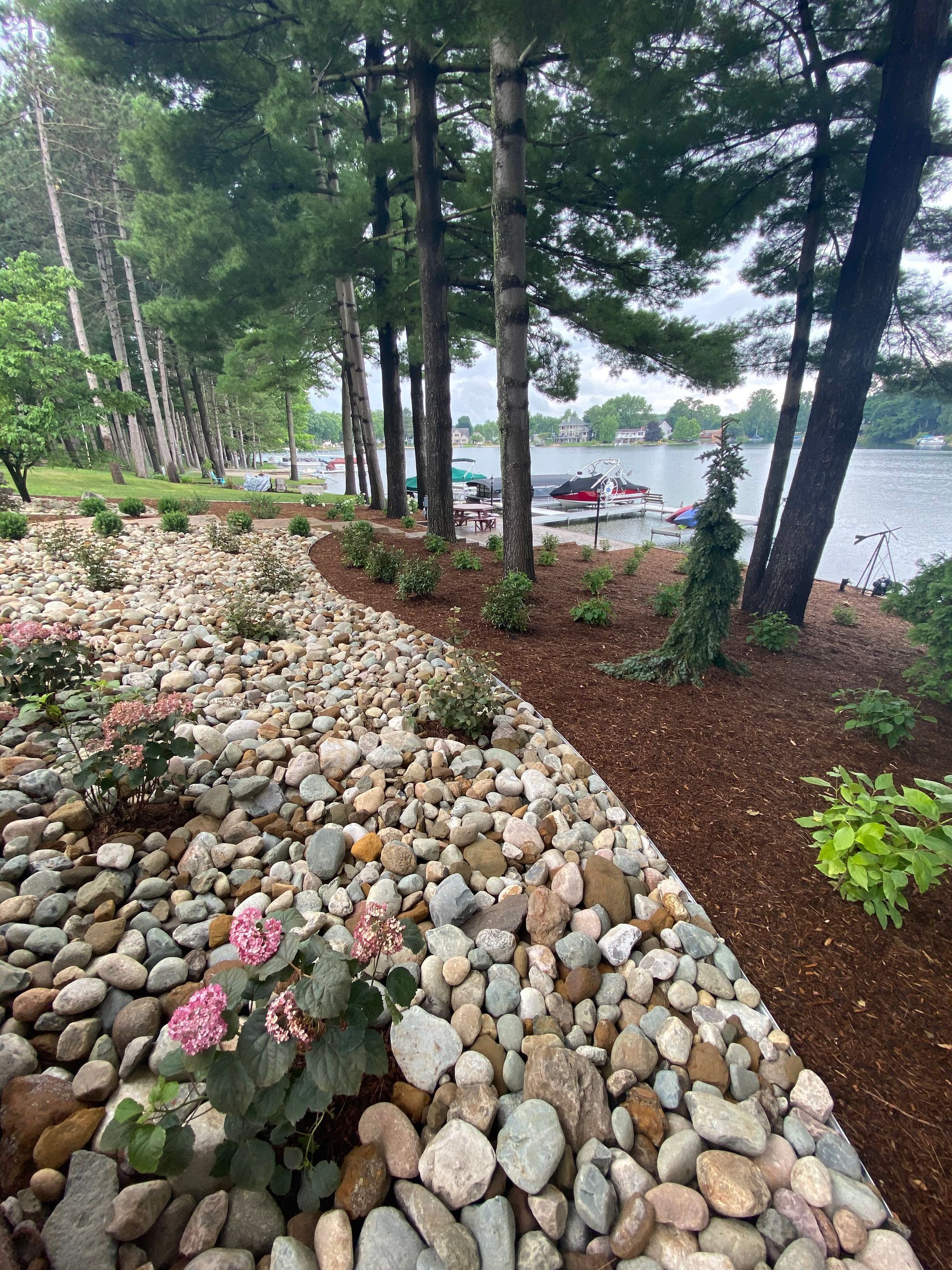 a rocky path leading to a lake with a boat in the background