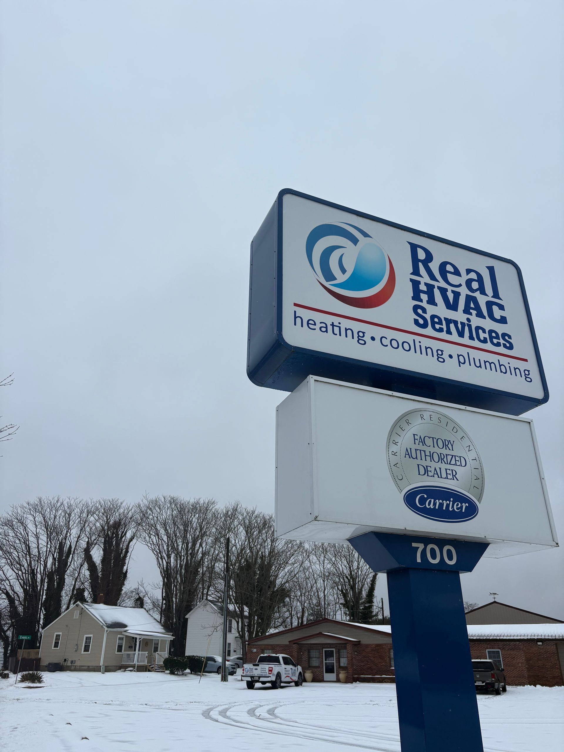 Real Star Services sign in snowy parking lot under overcast sky
