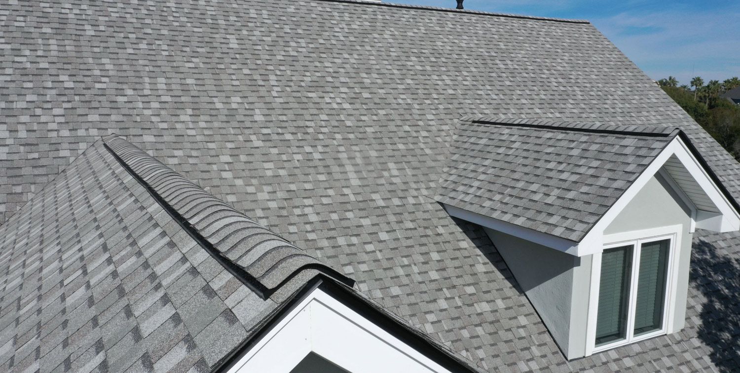 A house with a gray roof and a white window.