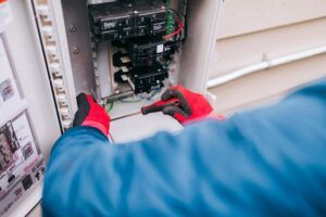 An electrician working on an electrical panel