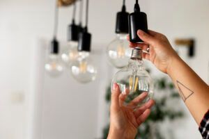 Person replacing hanging lightbulbs