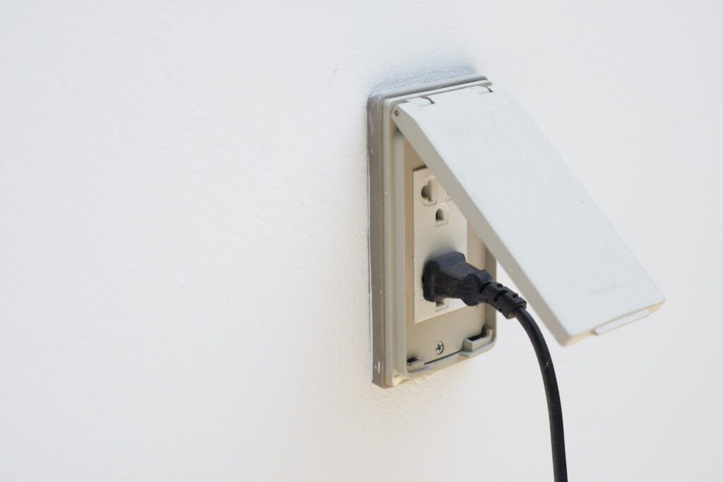 Black plug plugged in an outdoor outlet