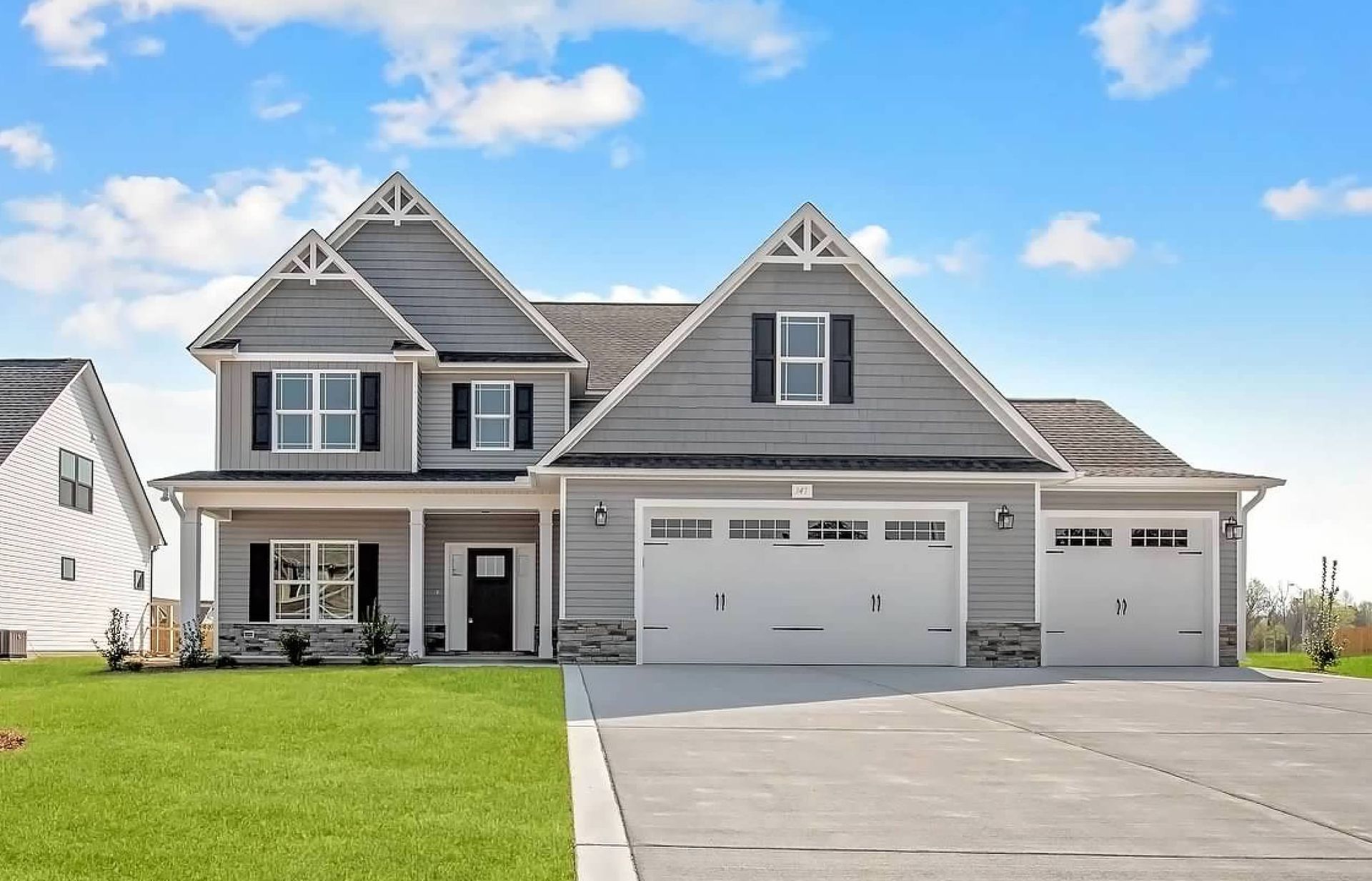 A large house with a lot of windows and a large driveway