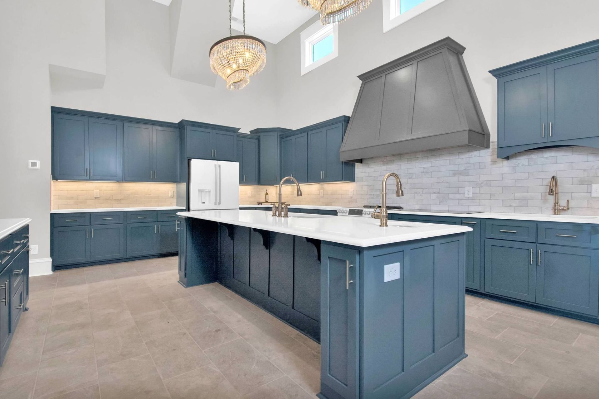 A large kitchen with blue cabinets and a large island