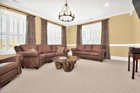 A living room with two couches , a coffee table , and a chandelier.