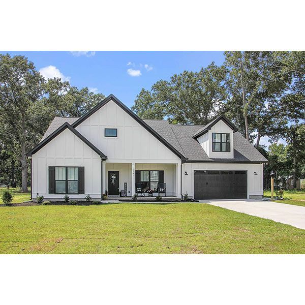 A white house with black trim and a black garage door is for sale.