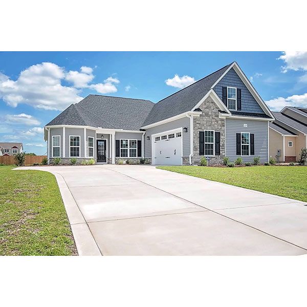 A large house with a concrete driveway leading to it.