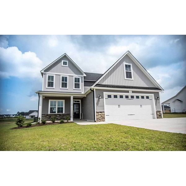 A large gray house with a white garage door is for sale.