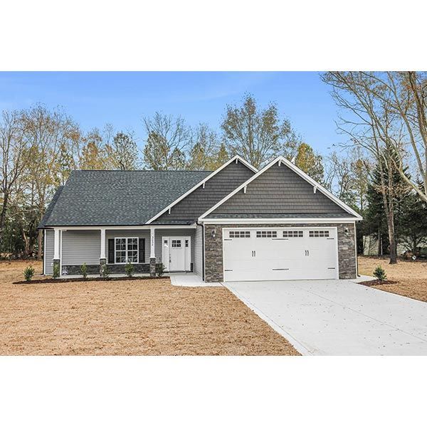 A house with a garage and a driveway in front of it.