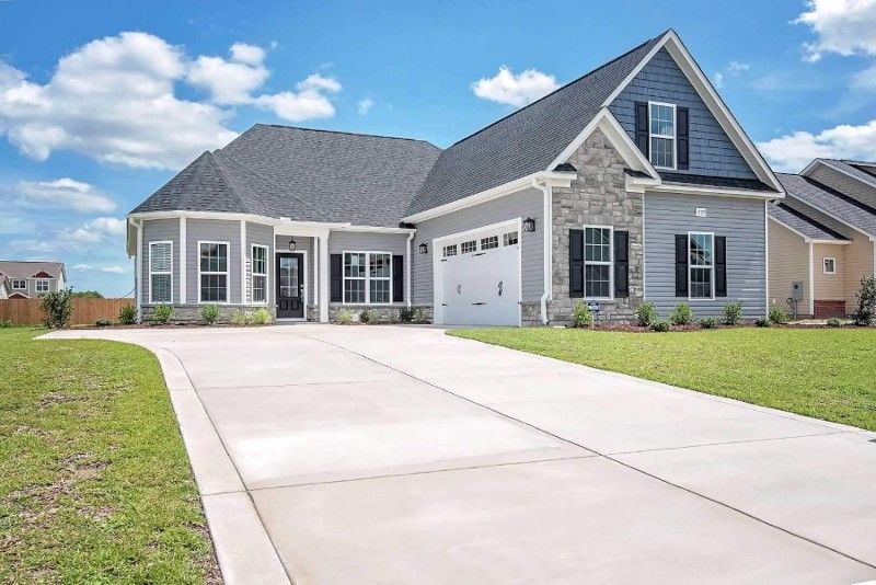 A large house with a concrete driveway leading to it.