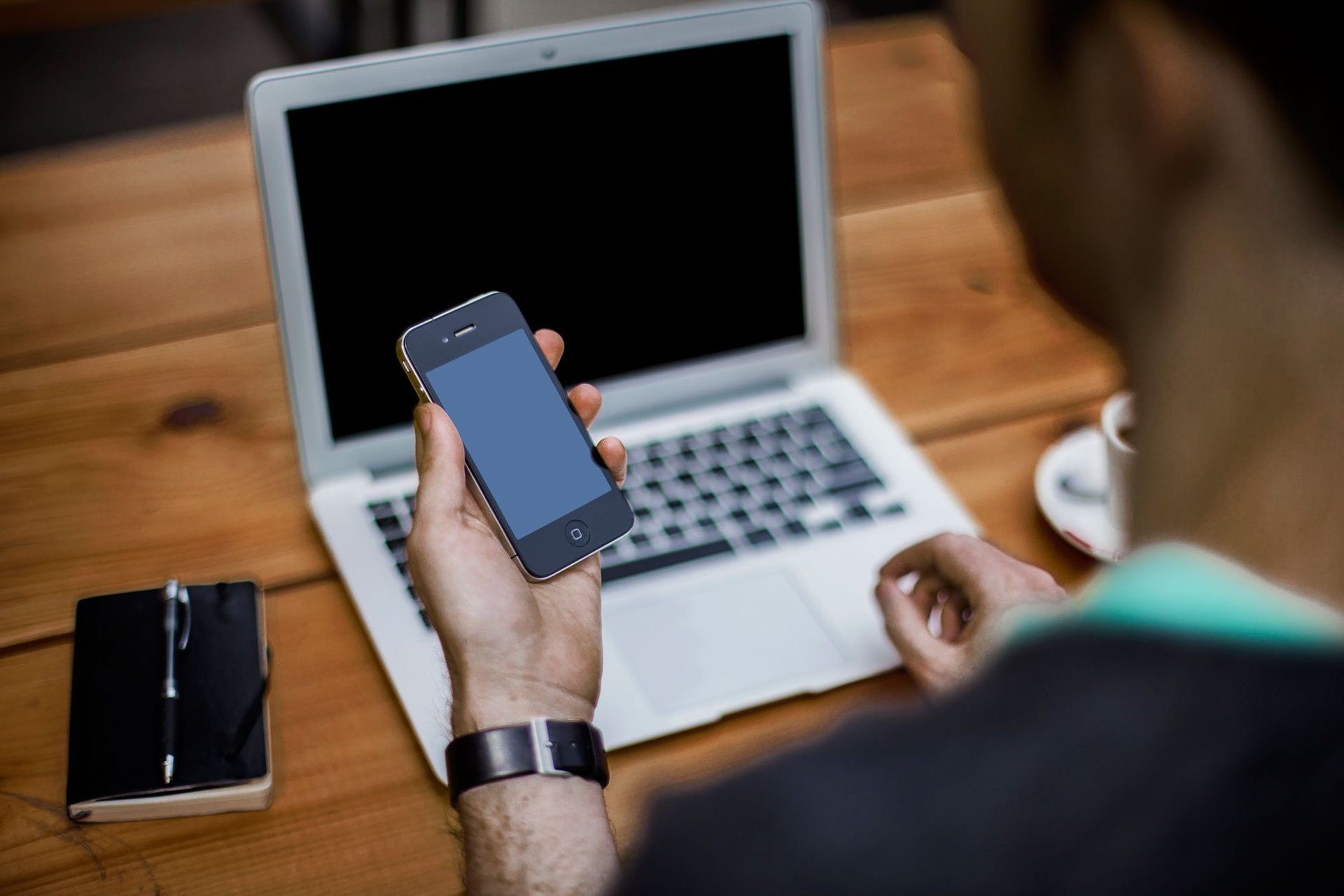 A man used his phone and laptop computer. 