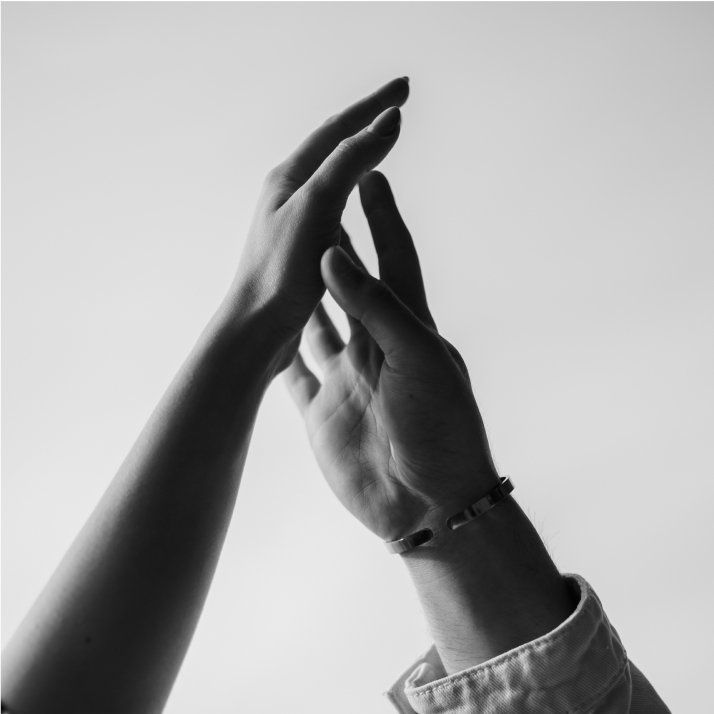 Two hands reaching up towards each other, black and white photo.
